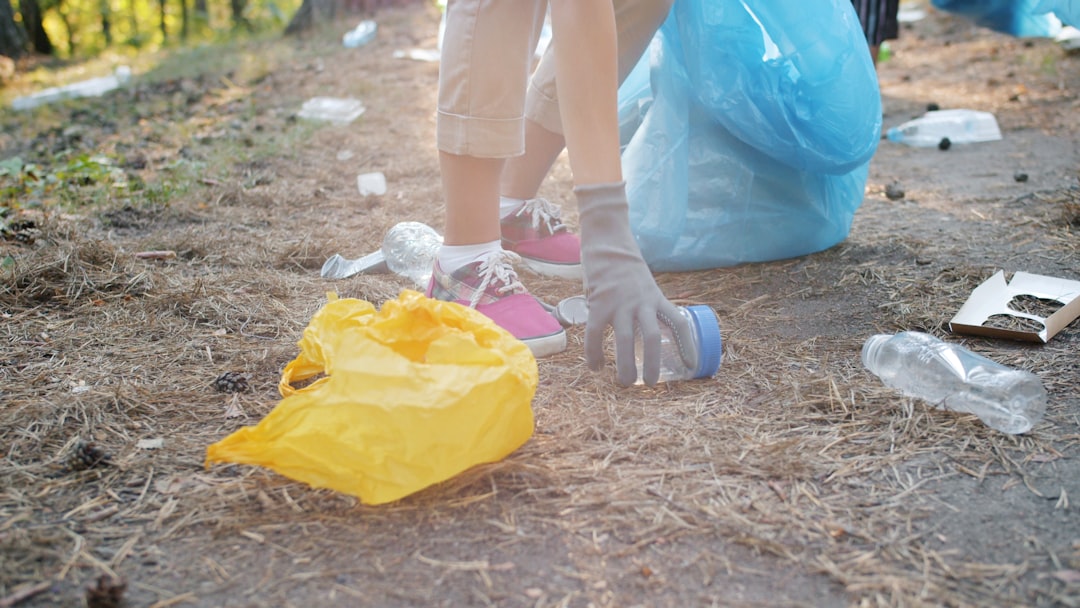 Multi-racial group of eco activists men and women are cleaning forest from junk smiling on sunny day in summer. People, volunteering and lifestyle concept.